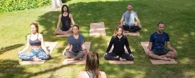 Group yoga practice outdoors with The Yoga Roots